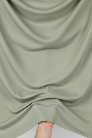 Olive green Tessuti satin unstitched shirting fabric from Mensfabric, smooth and shiny textile ideal for custom shirts.