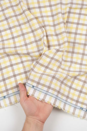 Yellow and brown checkered Tresca cotton shirting fabric by Arvind, featuring a white background with a luxurious unstitched design.