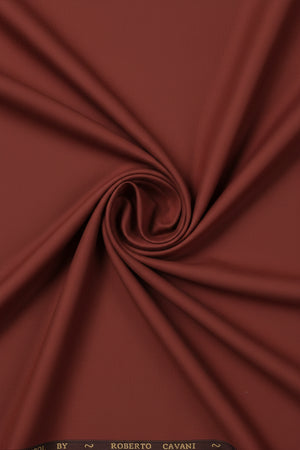 Roberto Cavali 140's poly wool suit fabric in rust red, showing a folded swatch with a smooth, textured finish.