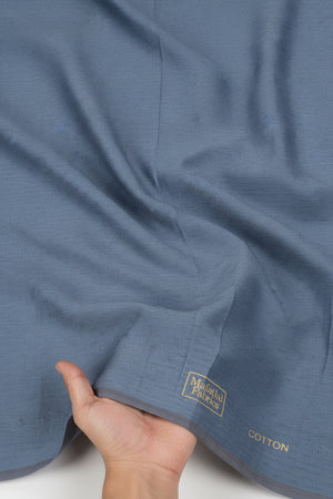 Close-up of a blue fabric with 'Cotton Fabrics' branding.