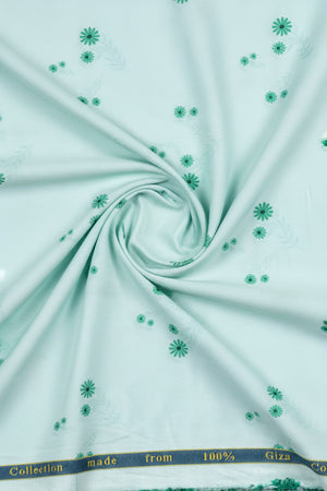 Light blue fabric with green floral patterns and '100% Cotton' label.