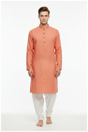 Arvind pure linen shirt fabric in carrot orange, unstitched, showing the textured linen material and vibrant color.
