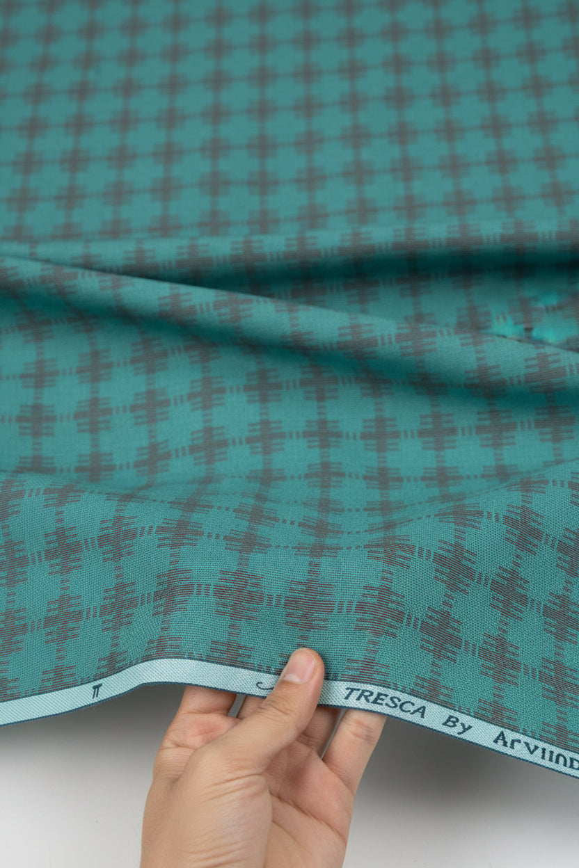 Teal green Tresca cotton shirting fabric by Arvind, showing a close-up of the unstitched fabric with a smooth texture.
