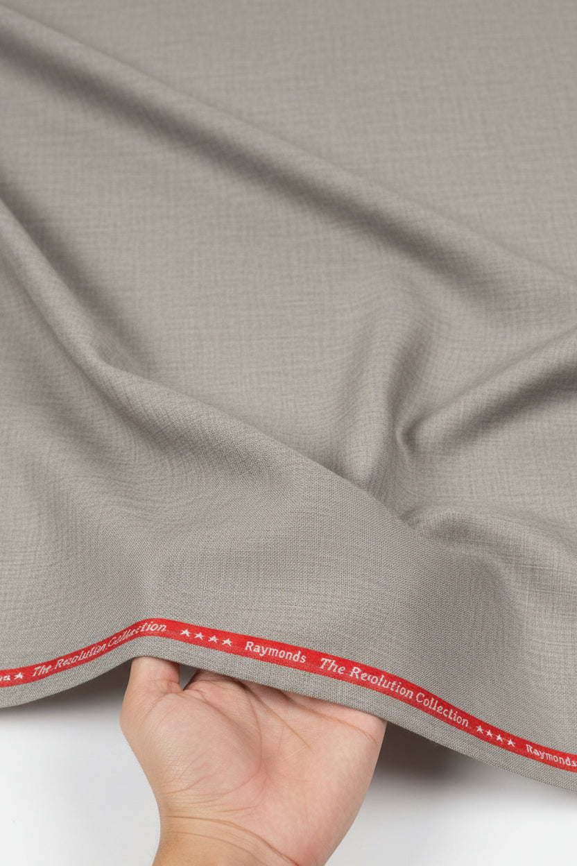 Raymond beige unstitched poly wool fabric for trousers and suiting, showing textured fabric detail and color.