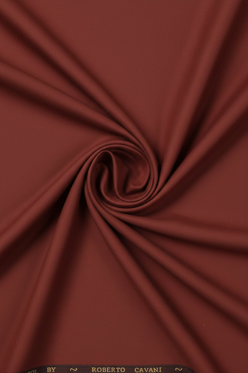 Roberto Cavali 140's poly wool suit fabric in rust red, showing a folded swatch with a smooth, textured finish.