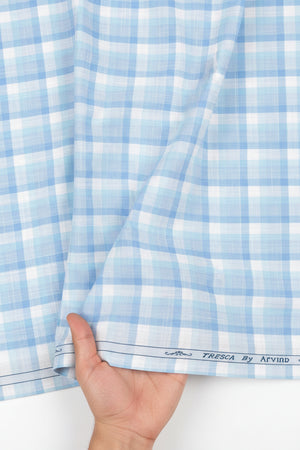 Crystal blue Tresca cotton checks shirting fabric by Arvind, showing a close-up of the soft, woven textile with checkered pattern.