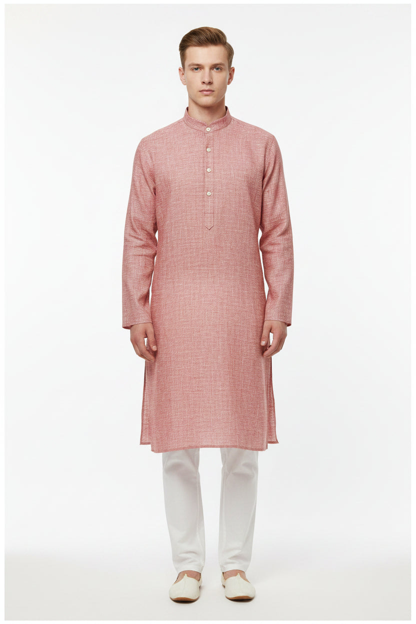 Light coral Arvind Tresca linen plain shirting fabric shown in natural folds, highlighting its smooth texture and soft color.
