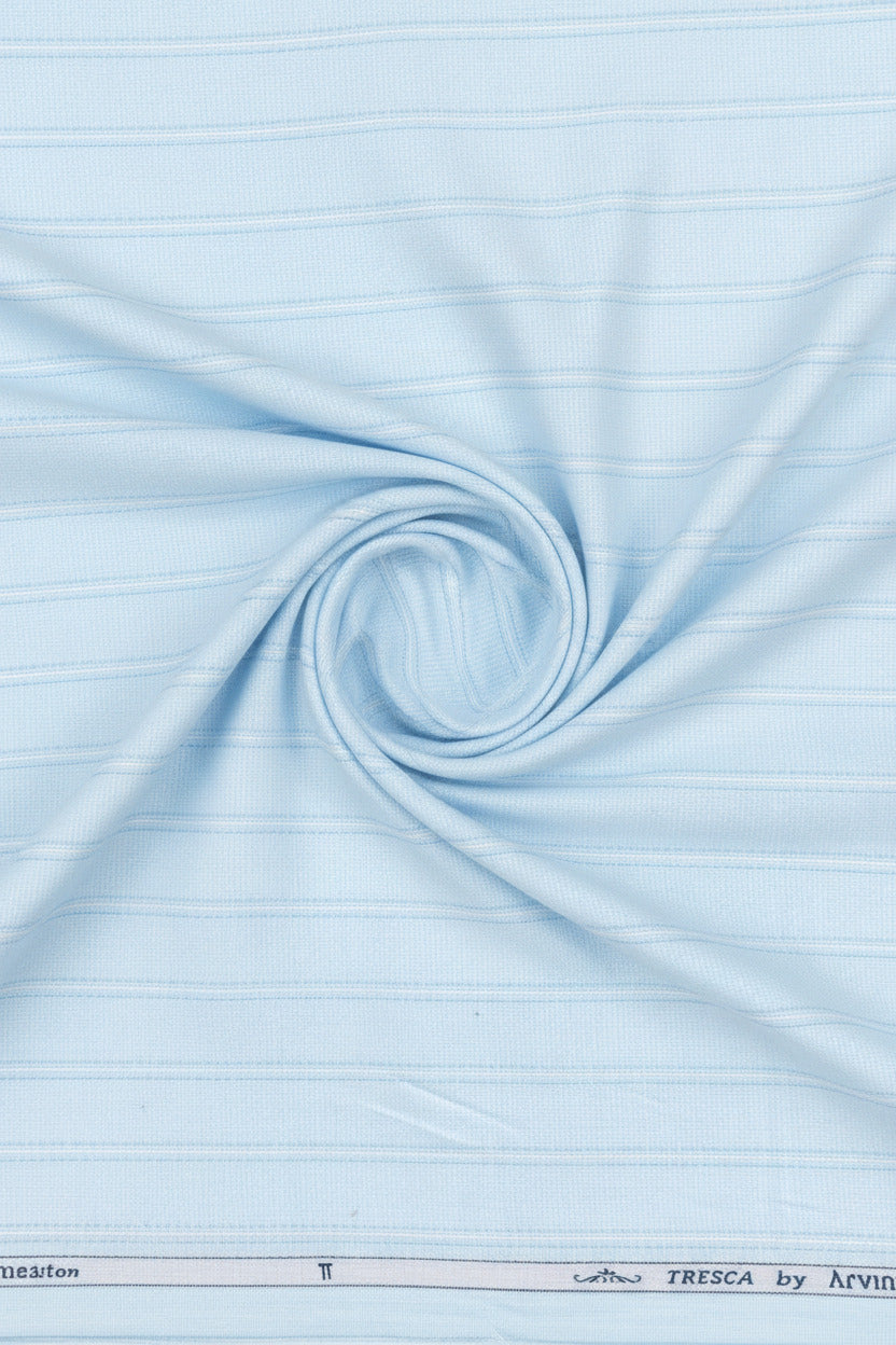 Close-up of light blue fabric with a subtle pattern, featuring the brand 'Arvind Tresca' at the bottom.