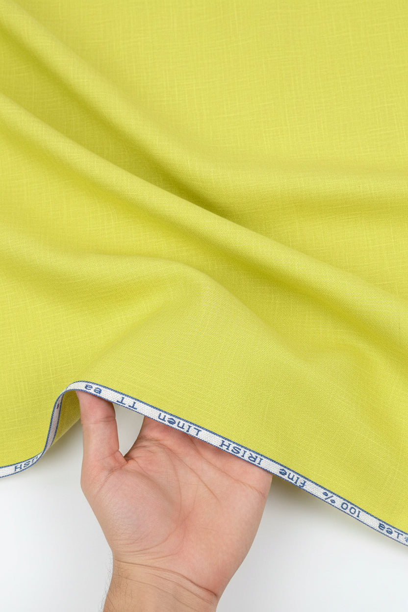 A close-up of a bright yellow-green linen fabric texture with a white header strip at the top containing blue printed text.