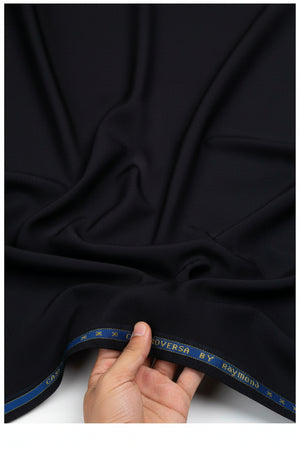 Black Raymond unstitched poly wool fabric for trousers and suits, showing a folded piece of suit material with texture.