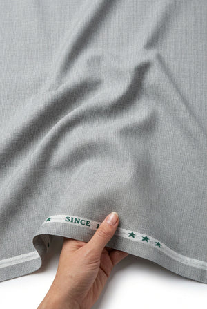 Light grey Arvind Lycra stretchable suiting fabric, showcasing smooth texture and flexibility for tailored garments.