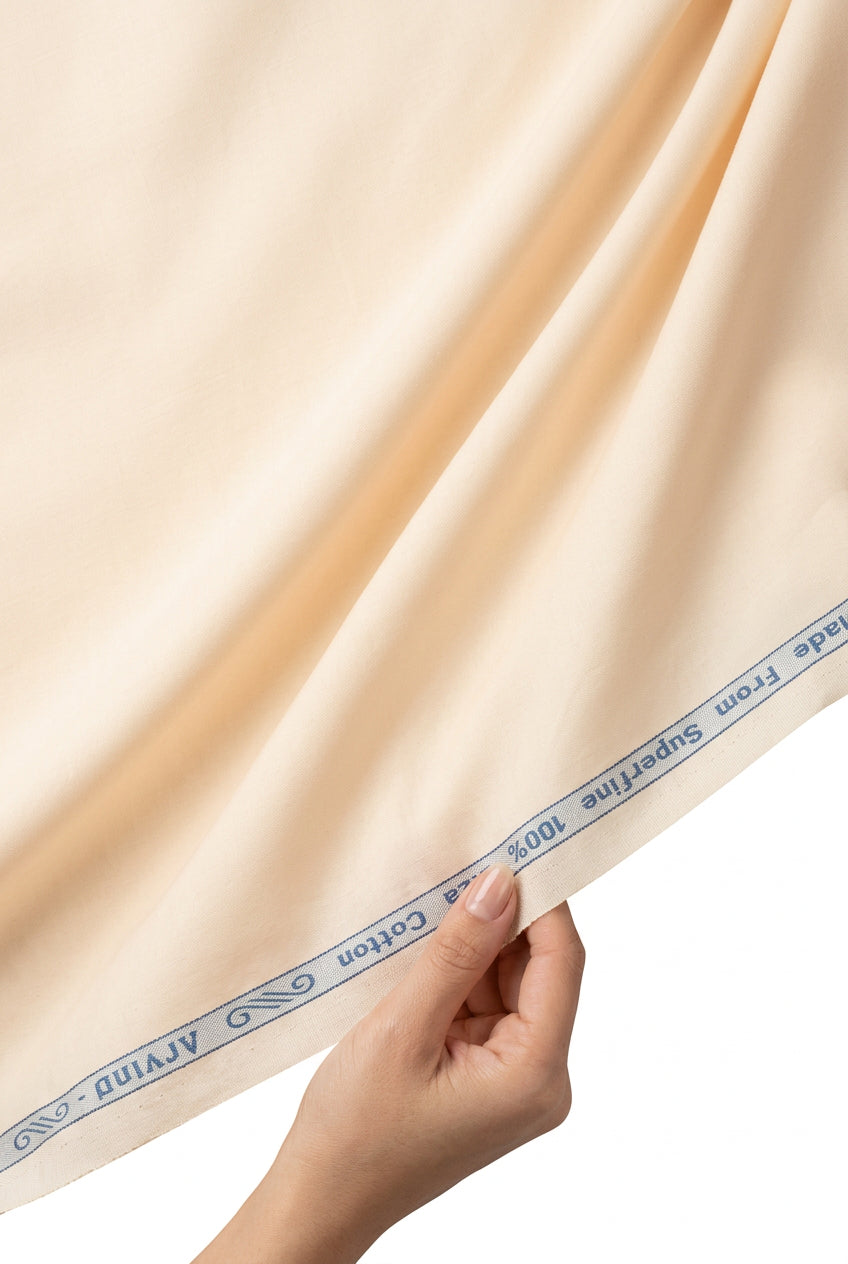 Peach cotton satin shirting fabric by ARVIND, featuring a smooth, shiny texture suitable for elegant shirts and apparel.
